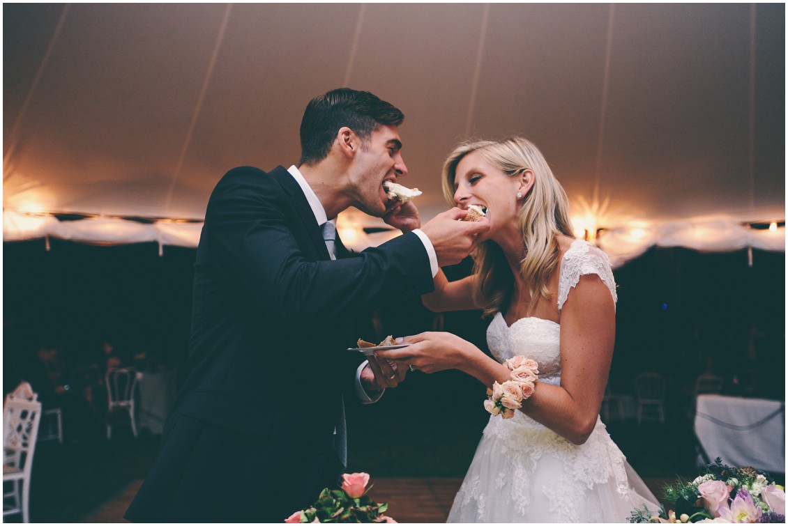 Bride and groom feeding each other the first slice of wedding cake at the reception. | My Eastern Shore Wedding | 