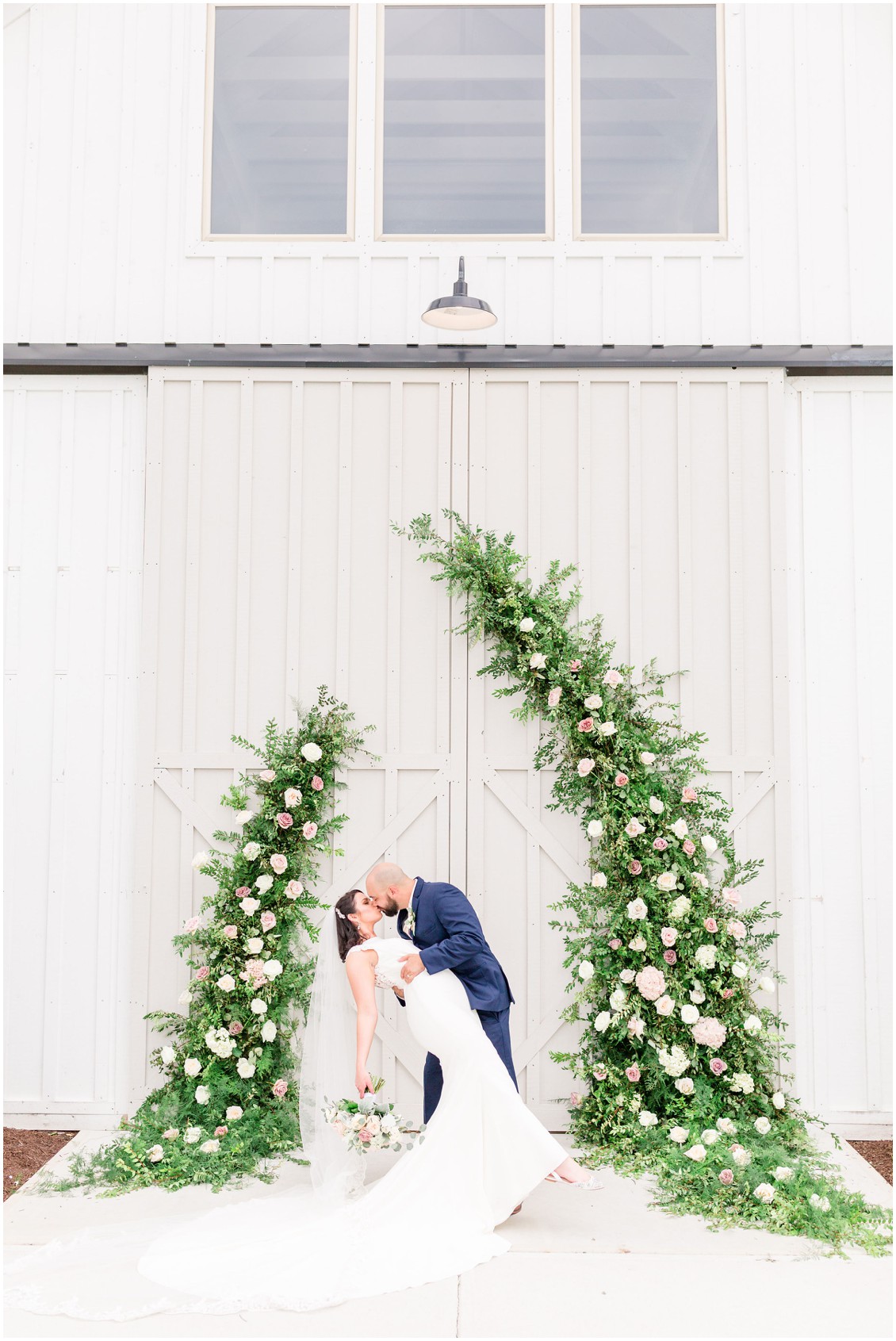 Bride and groom in front of J Starrs Flower Barn floral wall piece. | My Eastern Shore Wedding | 