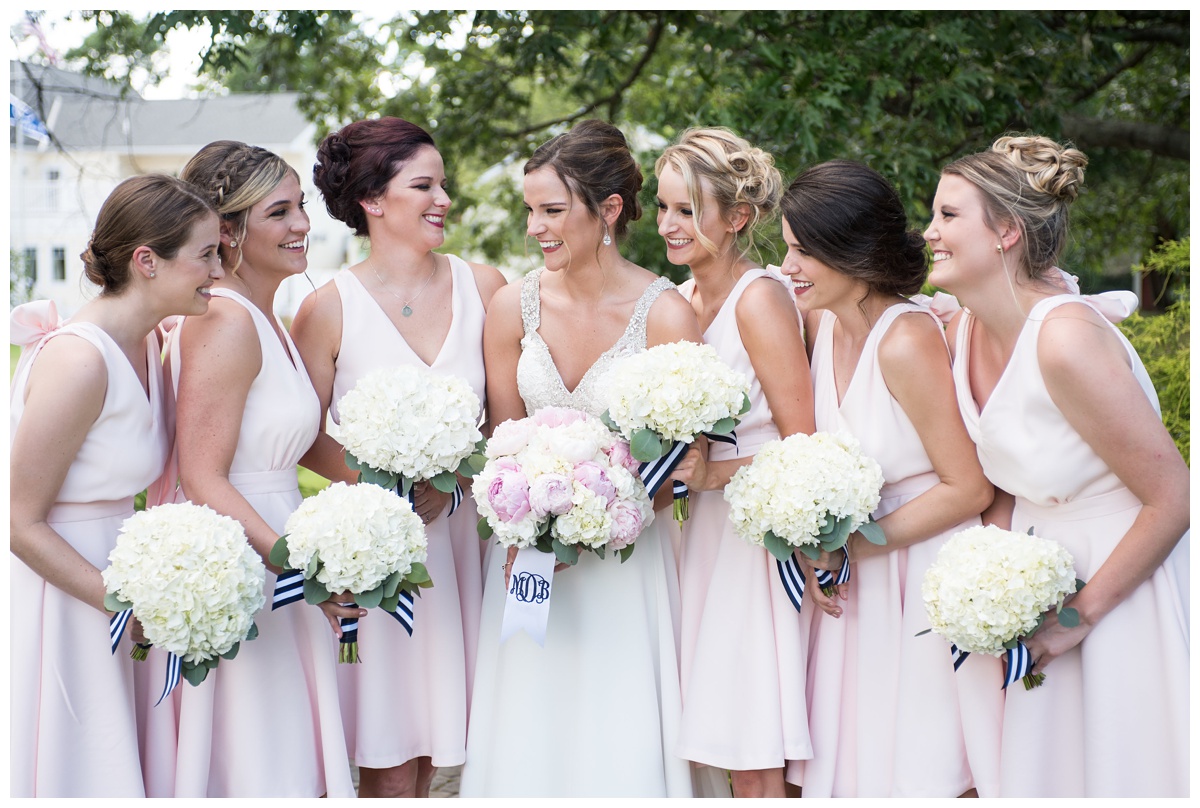 bride and bridesmaids photo - light pink blush bridesmaid dresses - cocktail knee length sleeveless - hydrangea wedding flower bouquets with navy blue and white striped ribbon - outdoors photo featured in My Eastern Shore Wedding