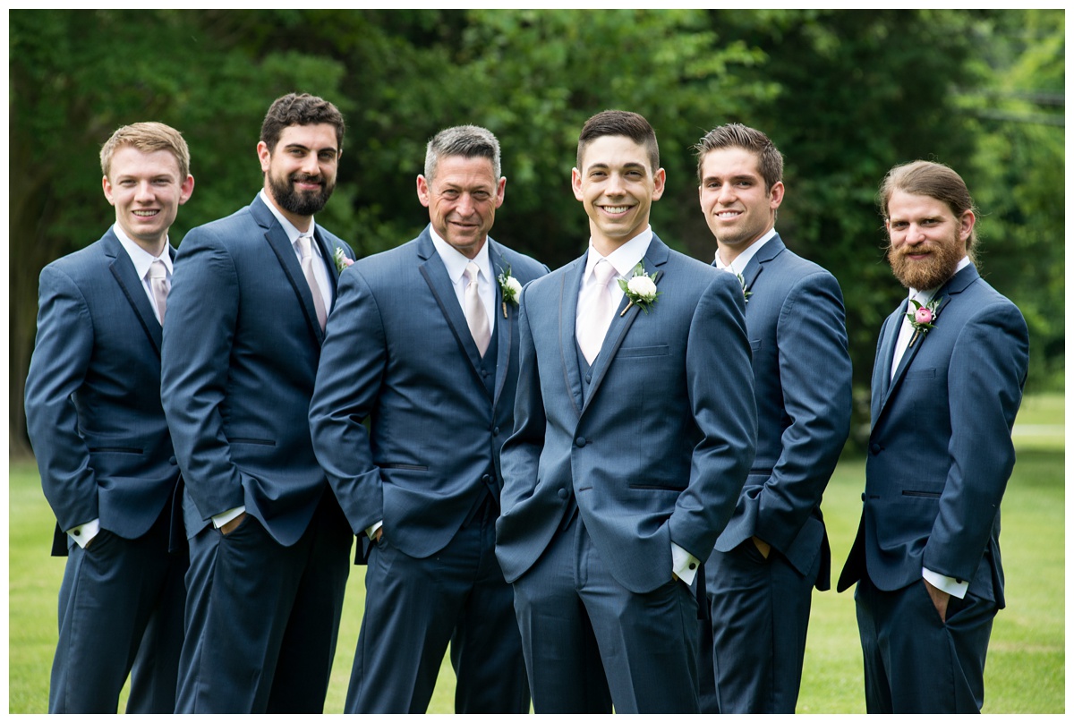 groom and groomsmen photo outdoors - navy suits with light pink ties - smiling - portrait ideas in the summer