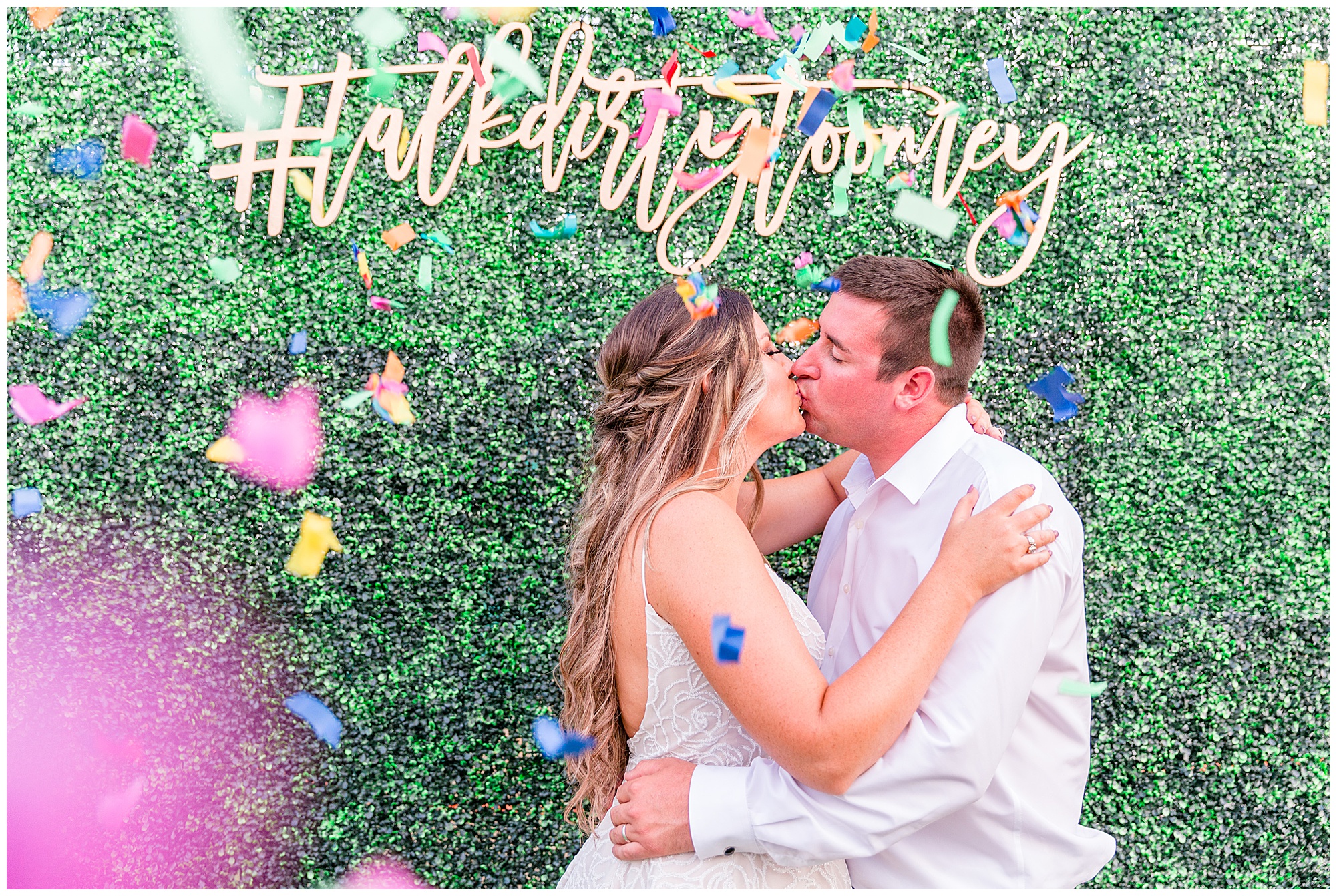 Wedding hashtag on backdrop behind kissing bride and groom. Photography by Cassidy MR Photography