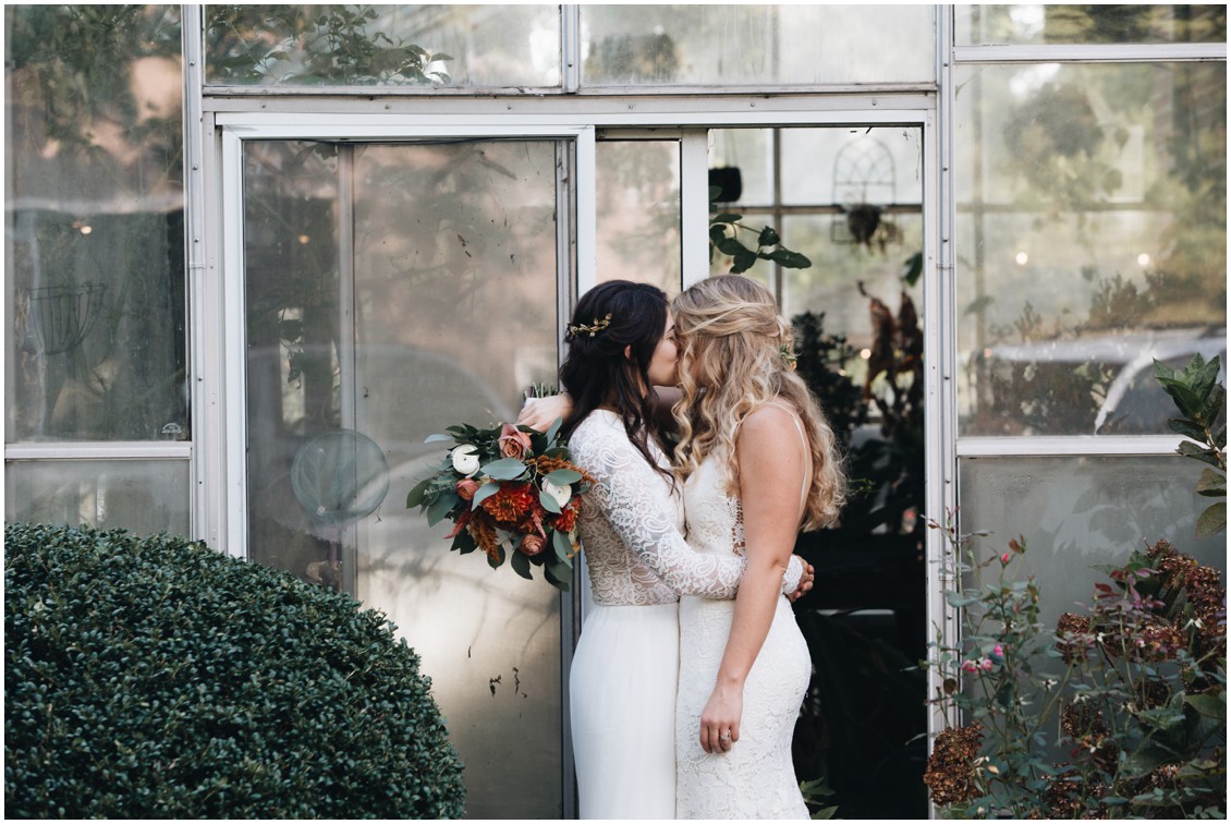Brides kissing in front of greenhouse | My Eastern Shore Wedding | Sherwood Florist | Cecile Storm Photography