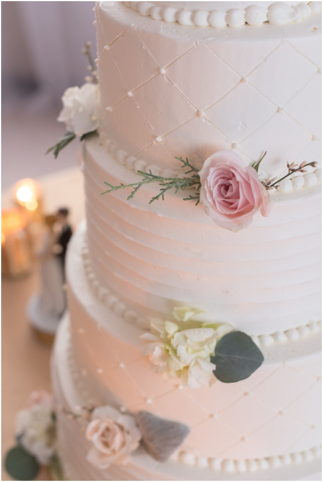Detail of cake with blush flowers, white details, sage greenery  | My Eastern Shore Wedding | Karena Dixon | Monteray Farms