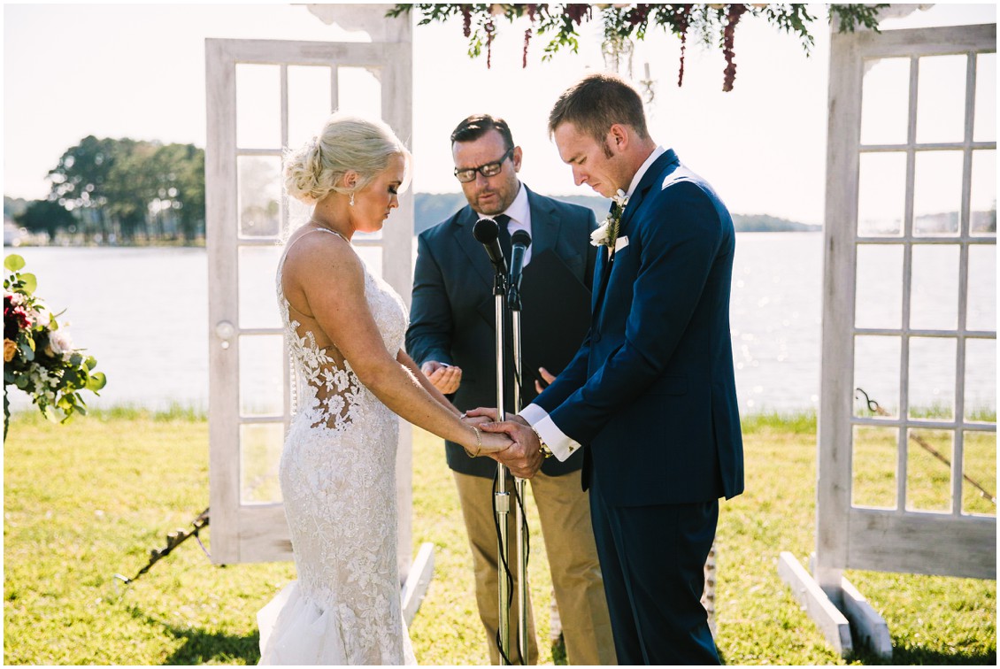 Bride and groom holding hands during outdoor ceremony | Kingsbay Mansion| My Eastern Shore Wedding