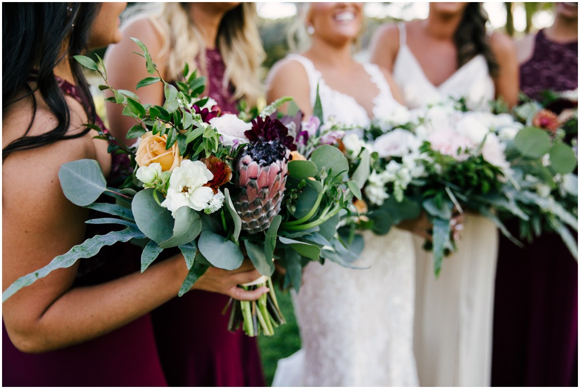 Bride and bridesmaids detail of floral bouquets with orange, dark red and protea| Kingsbay Mansion| My Eastern Shore Wedding