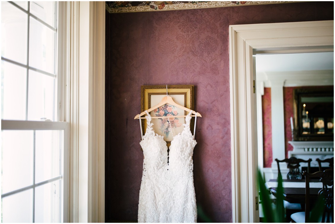 Bridal gown hanging on brocade wall | Kingsbay Mansion| My Eastern Shore Wedding