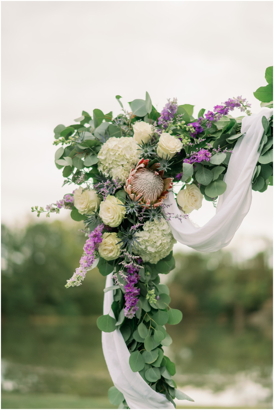 Floral arch, bridal bouquet with king protea and white flowers | My Eastern Shore Wedding | The Oaks | J Starr Flower Barn