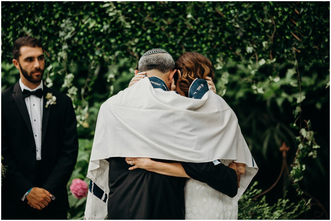 Bride and groom under prayer shawl during wedding ceremony | My Eastern Shore Wedding | Sherwood Florist