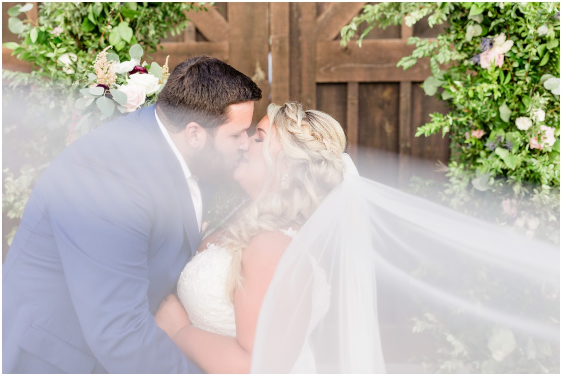 Bride and groom kissing with veil sweeping, pink and blue wedding | My Eastern Shore Wedding | Cassidy Mister Photography