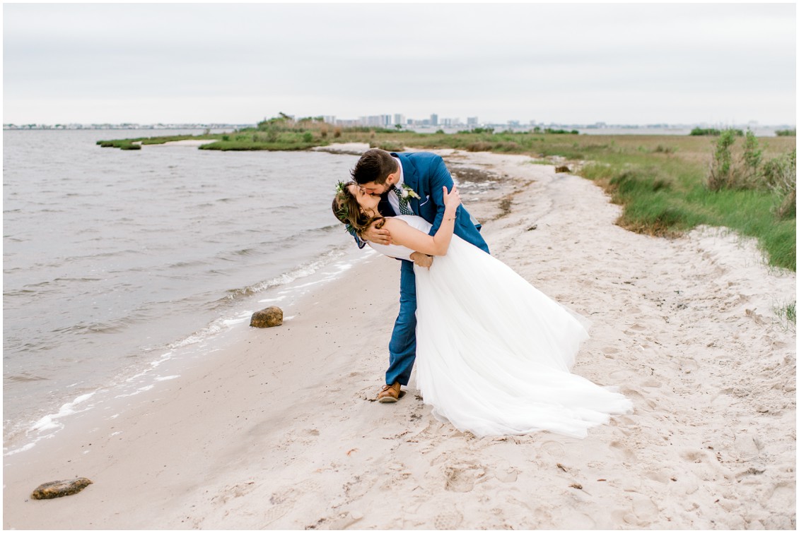 Bride and groom kissing on beach following ceremony | Naturally Beautiful Bayside Wedding | My Eastern Shore Wedding | Erin Wheeler Photography | Bayside Resort Golf Club