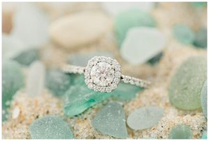 A white gold, halo diamond engagement ring surrounded by dusty blue and soft green sea glass. | My Eastern Shore Wedding