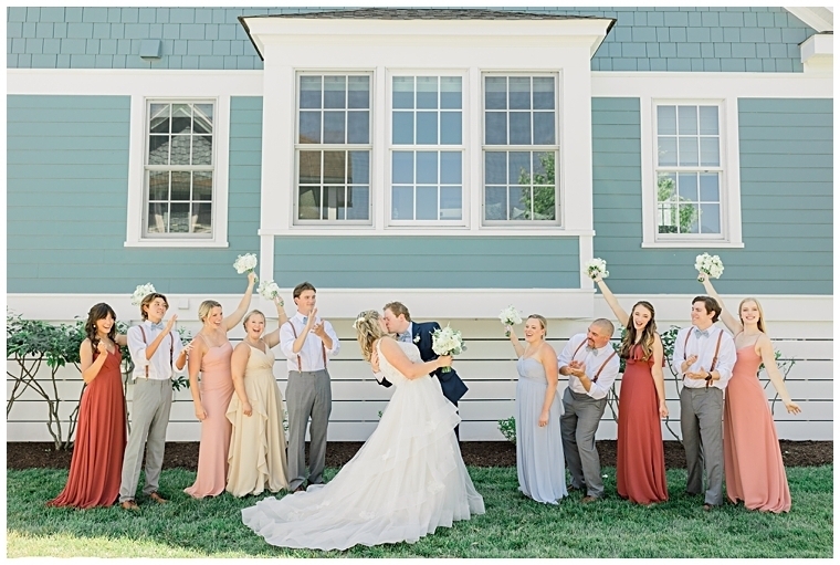 The bridal party cheers as the newlyweds share a kiss  | Inn at Haven Harbour 