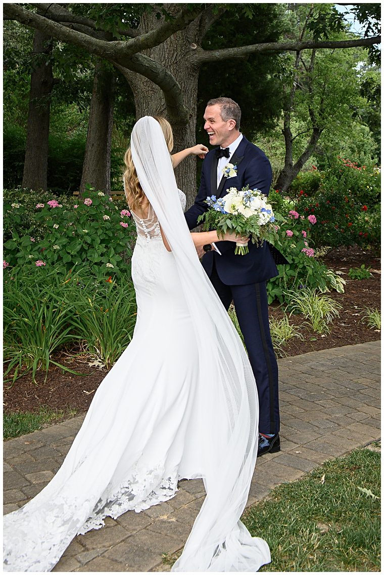 The groom sees his bride for the first time before the ceremony in the gardens at The Oaks Waterfront Inn