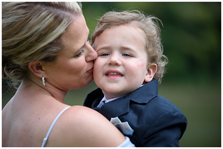 A bridesmaid kisses the ring-bearer on the cheek.