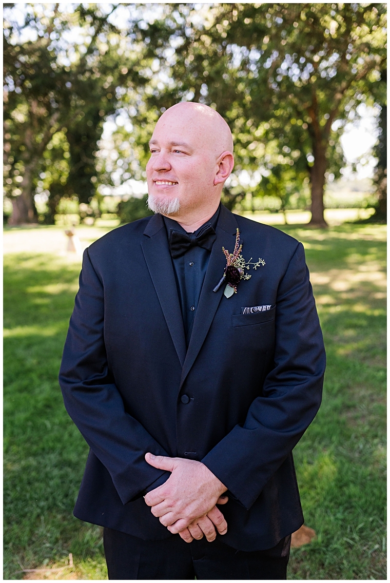 The groom poses for a portrait in his navy blue suit at Worsell Manor.