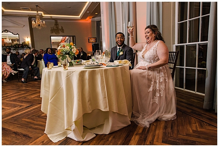 Enjoying their sweethearts table in the Tidewater Ballroom, the new bride and groom toast to their marriage | Laura's Focus Photography