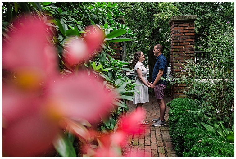 Framed by florals, the couple holds hands in the beautiful historic gardens | Laura's Focus Photography