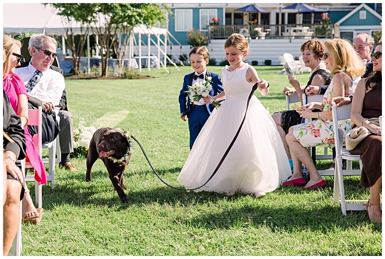 The flower girl walks their adorable flower pup down the aisle to join the ceremony