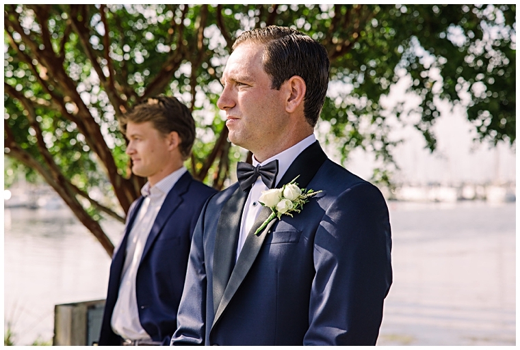 The groom awaits his bride's arrival at the alter dressed in a blue tuxedo on the waterfront at Haven Harbour Marina Resort | Inn at Haven Harbour | Laura's Focus Photography | My Eastern Shore Wedding