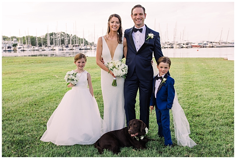 A family portrait with the bride a groom, their flower dog, and their flower girl and ring bearer on the lawn at Haven Harbour Marina Resort | Inn at Haven Harbour | Laura's Focus Photography | My Eastern Shore Wedding