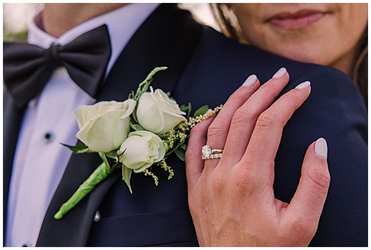 A gorgeous detail shot of the bride's wedding ring on her hand resting on her new husband's shoulder.