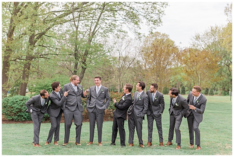 The groomsmen celebrate with the groom on the lawn at The Oaks