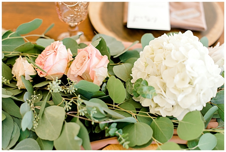 Blush pink roses and white hydrangeas dress the centerpieces at this family reception