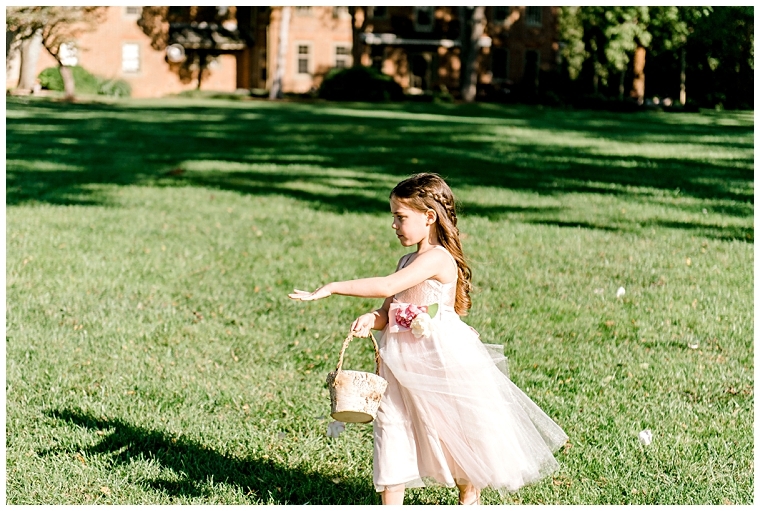 The flower girl dusts the aisle with petals as she processes into the ceremony