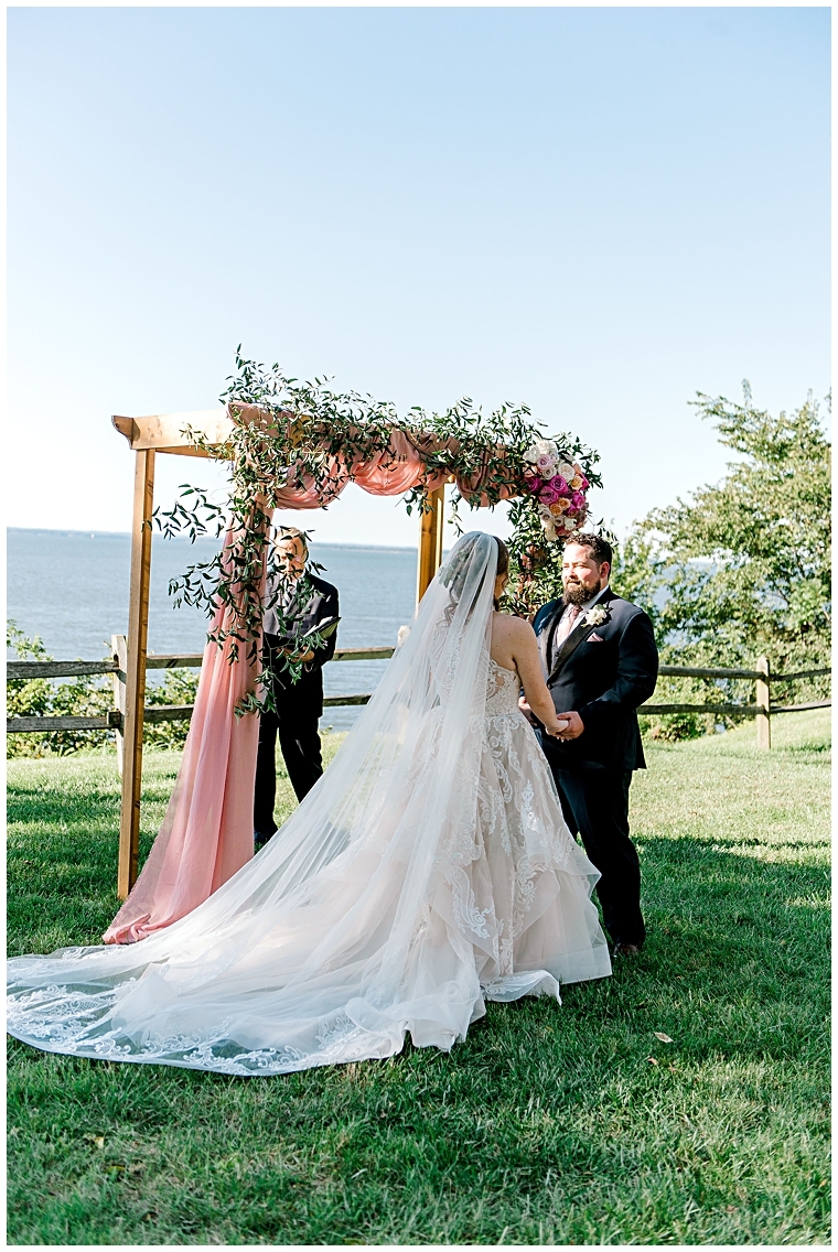 Waterfront ceremony at Great Oak Manor with a floral arch