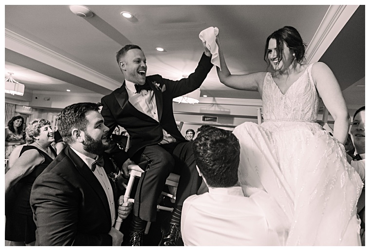 The newlyweds are lifted in the air to celebrate their marriage at their reception at The Oaks Waterfront Hotel | Laura's Focus Photography | My Eastern Shore Wedding