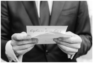 The groom reads a note from his bride as they get ready for the big day