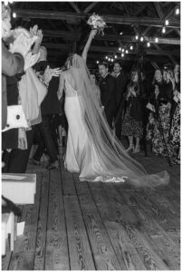 The bride and groom exit their ceremony with celebratory cheers as they walk down the aisle in the boat house at The Chesapeake Bay Maritime Museum | My Eastern Shore Wedding