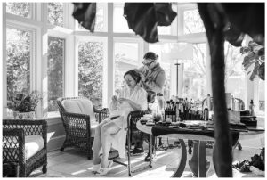 The bride sits to have her hair and makeup done.
