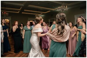 The bridal party surrounds the bride on the dance floor