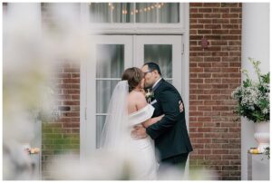 The new husband and wife share their first kiss as newlyweds to conclude their outdoor ceremony at The Tidewater Inn