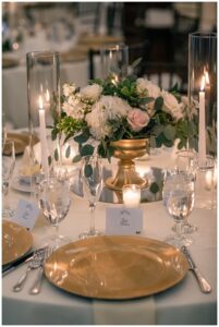 The tables are decorated with gold details and white and pink florals