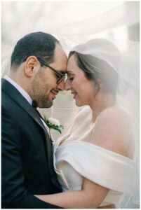 The bride and groom share a quiet moment before the ceremony hidden behind her gorgeous lace veil