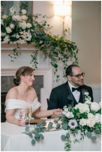 The bride and groom sit at a sweetheart table to enjoy their first dinner as newlyweds