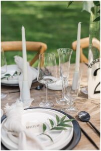 A beautiful tablescape with white linens and subtle greenery by Three Little Buds