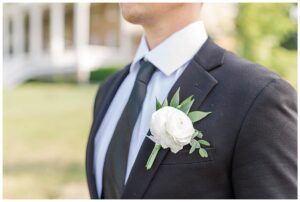 A single white rose dons the groom's suit for his wedding day