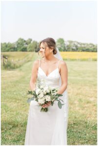 A bridal portrait with a white and green bouquet by Three Little Buds