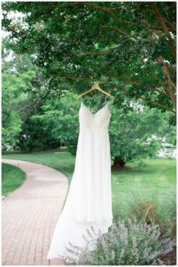 On a personalized bridal hanger, the wedding gown hangs for a portrait
