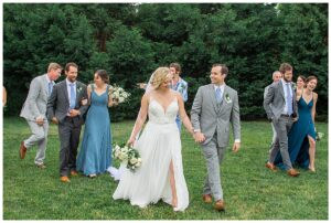 The newlyweds exit their ceremony as husband and wife followed by an elated bridal party dressed in blues and greys.