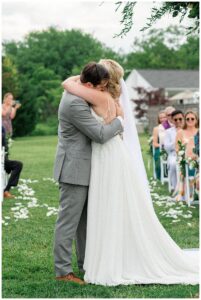 Celebrating their first appearance as husband and wife, the newlyweds embrace in a hug before departing the ceremony.