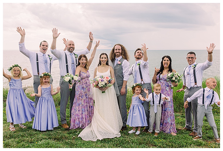The bridal party celebrates the bride and groom on the waterfront at Black Walnut Point Inn | Laura's Focus Photography