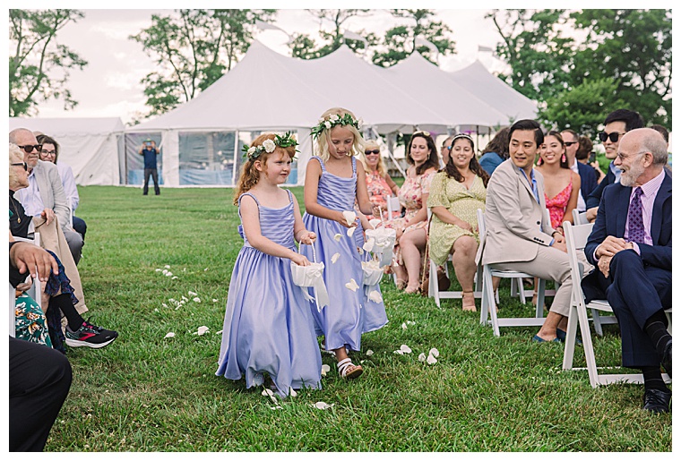 The flower girls walk down the aisle lining it with petals as they wait for the bride