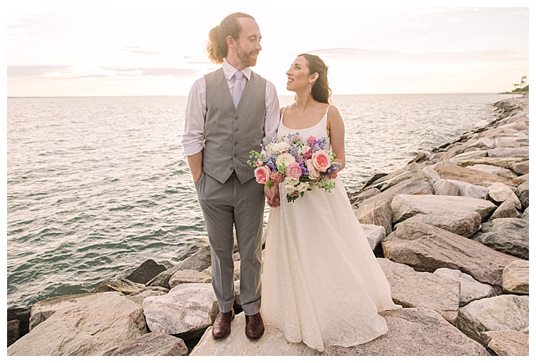 The bride and groom enjoy a waterfront walk at Black Walnut Point Inn | Laura's Focus Photography