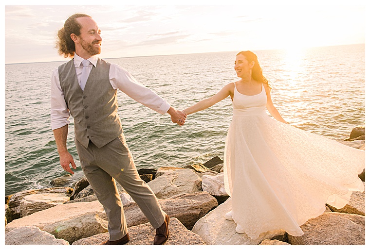 The bride and groom take a walk by the waterfront during the sunset at Black Walnut Point Inn | Laura's Focus Photography
