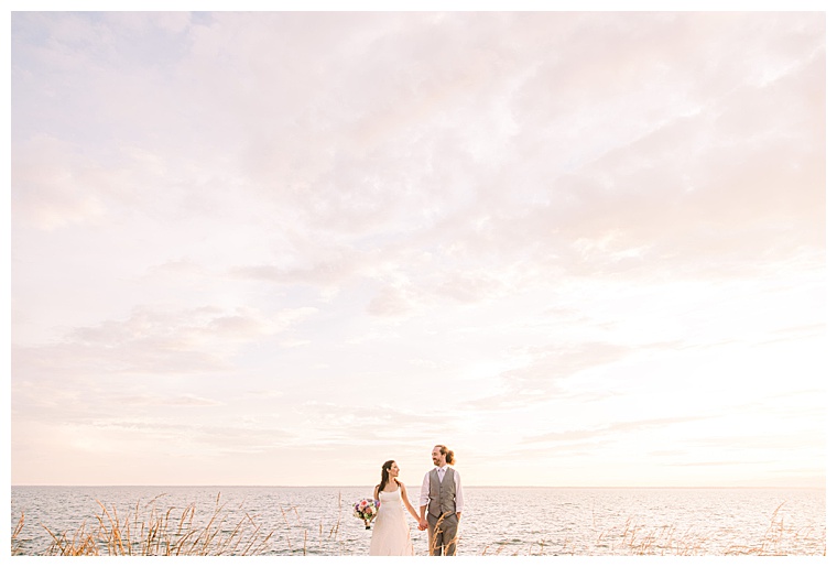 The bride and groom pose for a portrait on the waterfront at Black Walnut Point Inn | Laura's Focus Photography