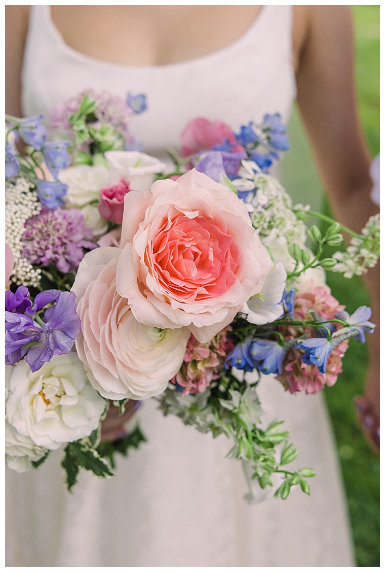 Pastel pinks, purples, and blues with pops of greenery by Sherwood Florist create this colorful bouquet for the bride